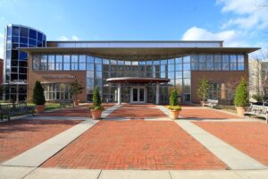 The outside of the Montclair Public Library, including a brick walkway and glass front of the building.