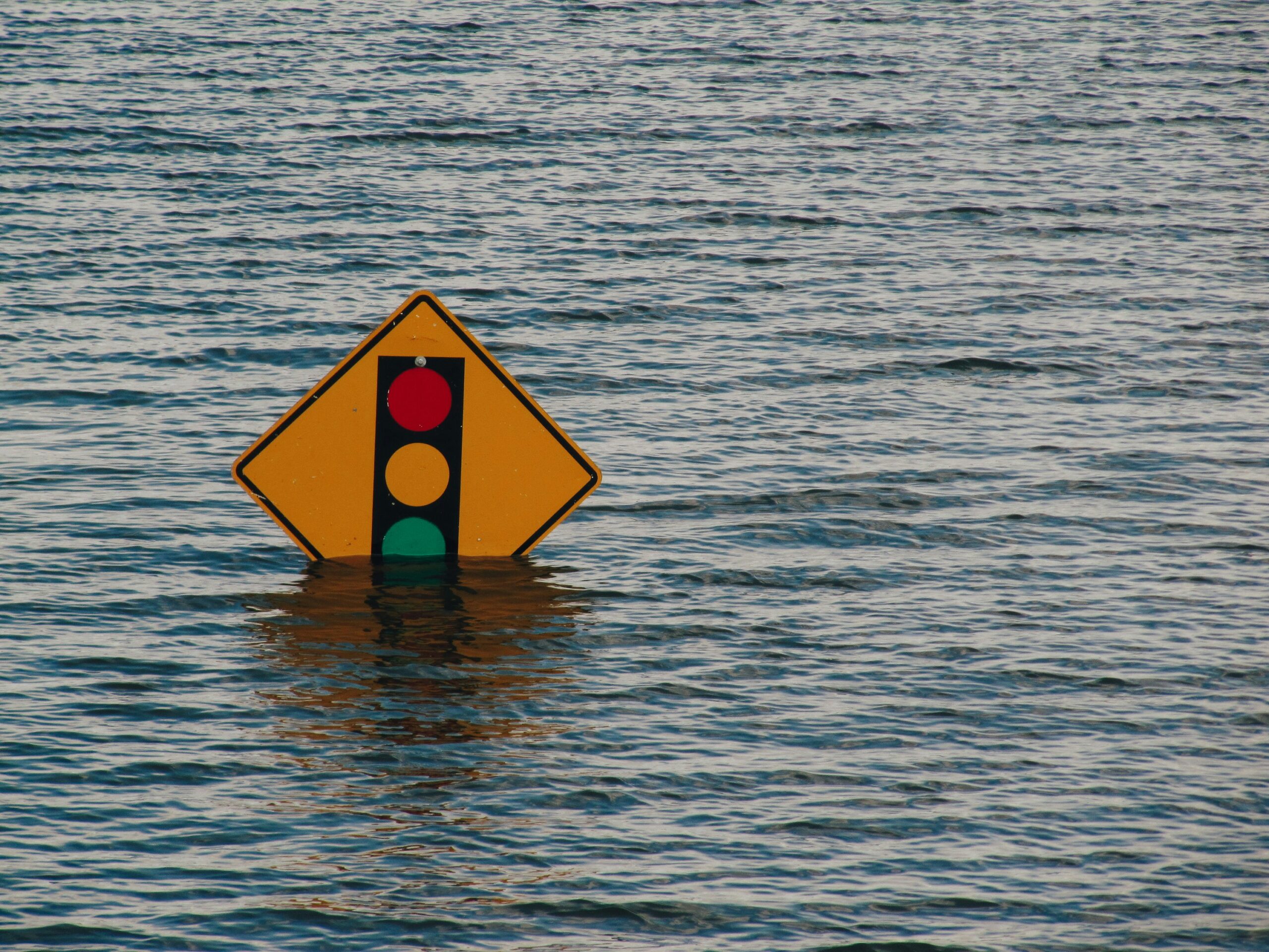 Image of a road sign submerged in water during a flood.